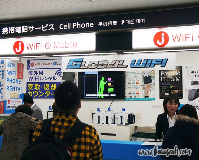 Getting our WiFi router from a telecom booths at Narita Airport